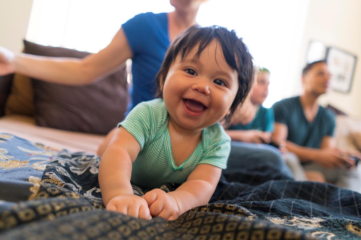 baby smiling widely on a sofa