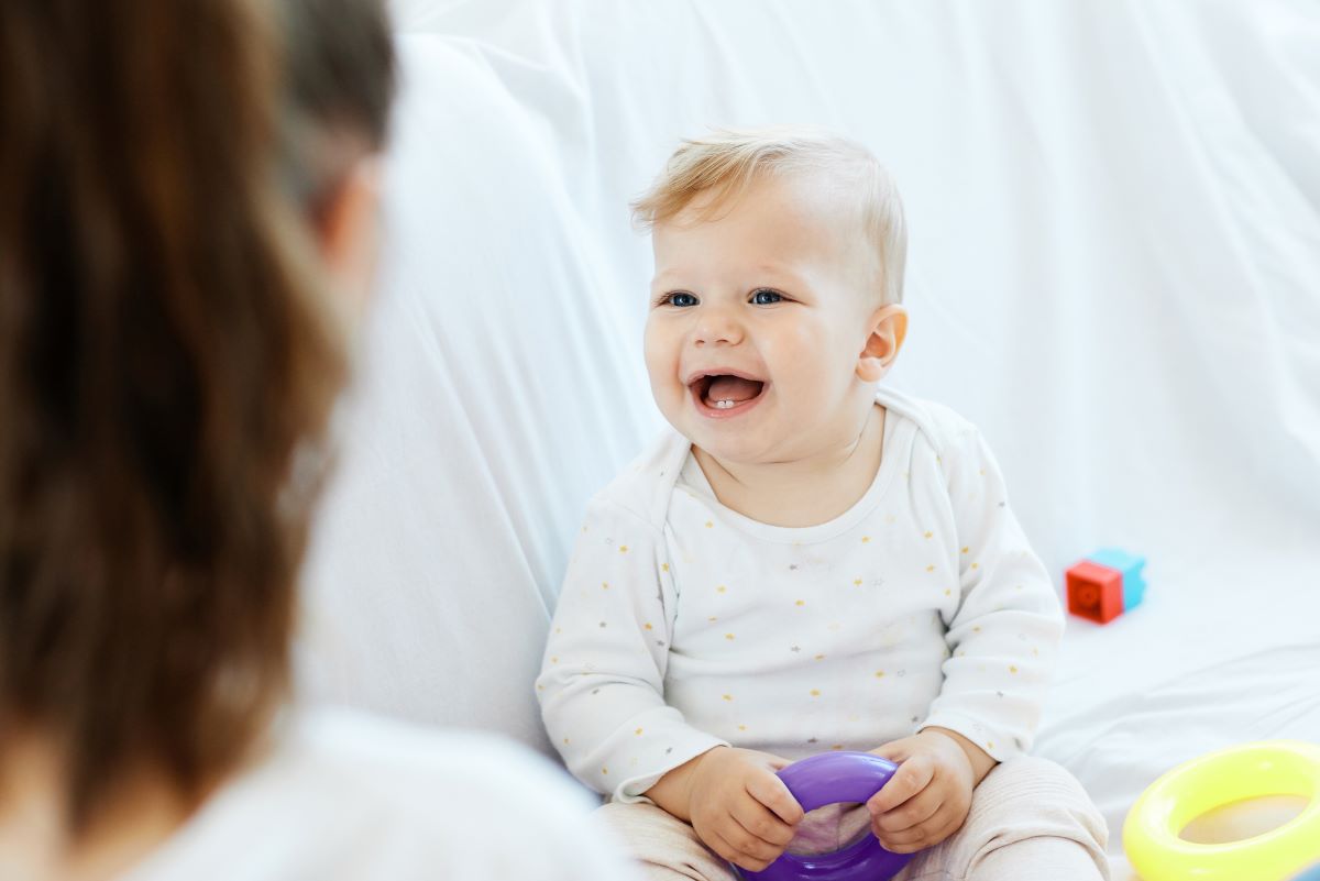 baby playing with toy and smiling