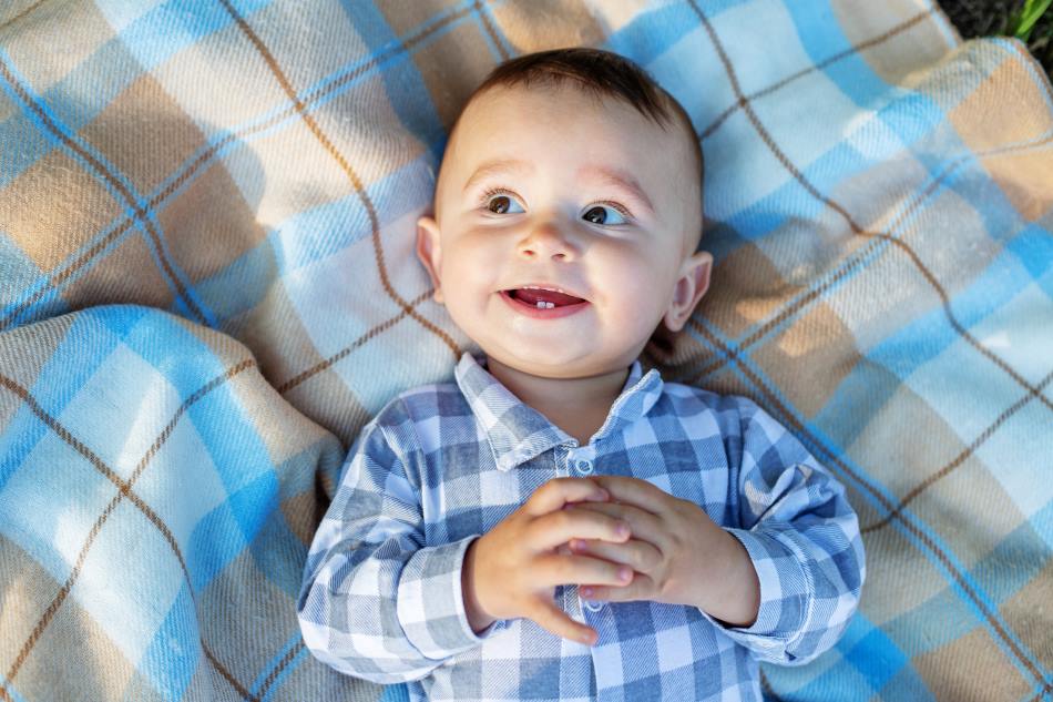 cute baby lying on blanket and smiling