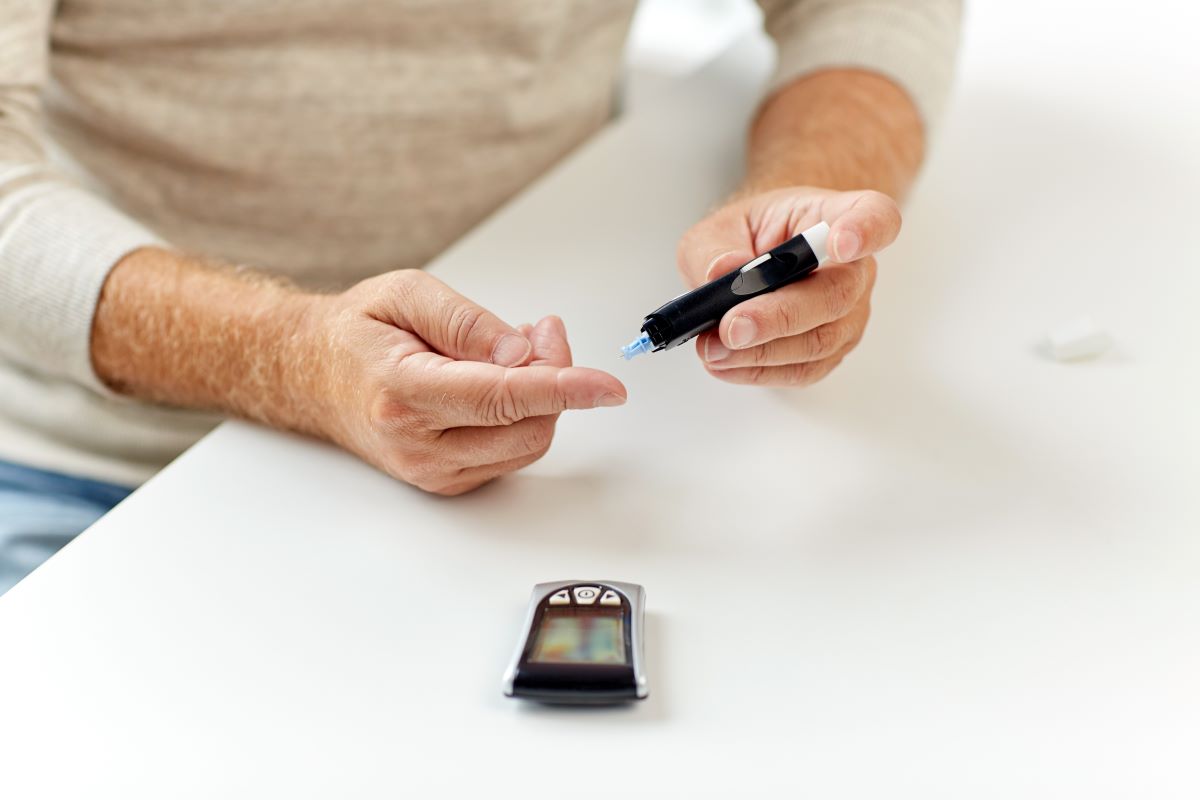 man with glucometer checking blood sugar