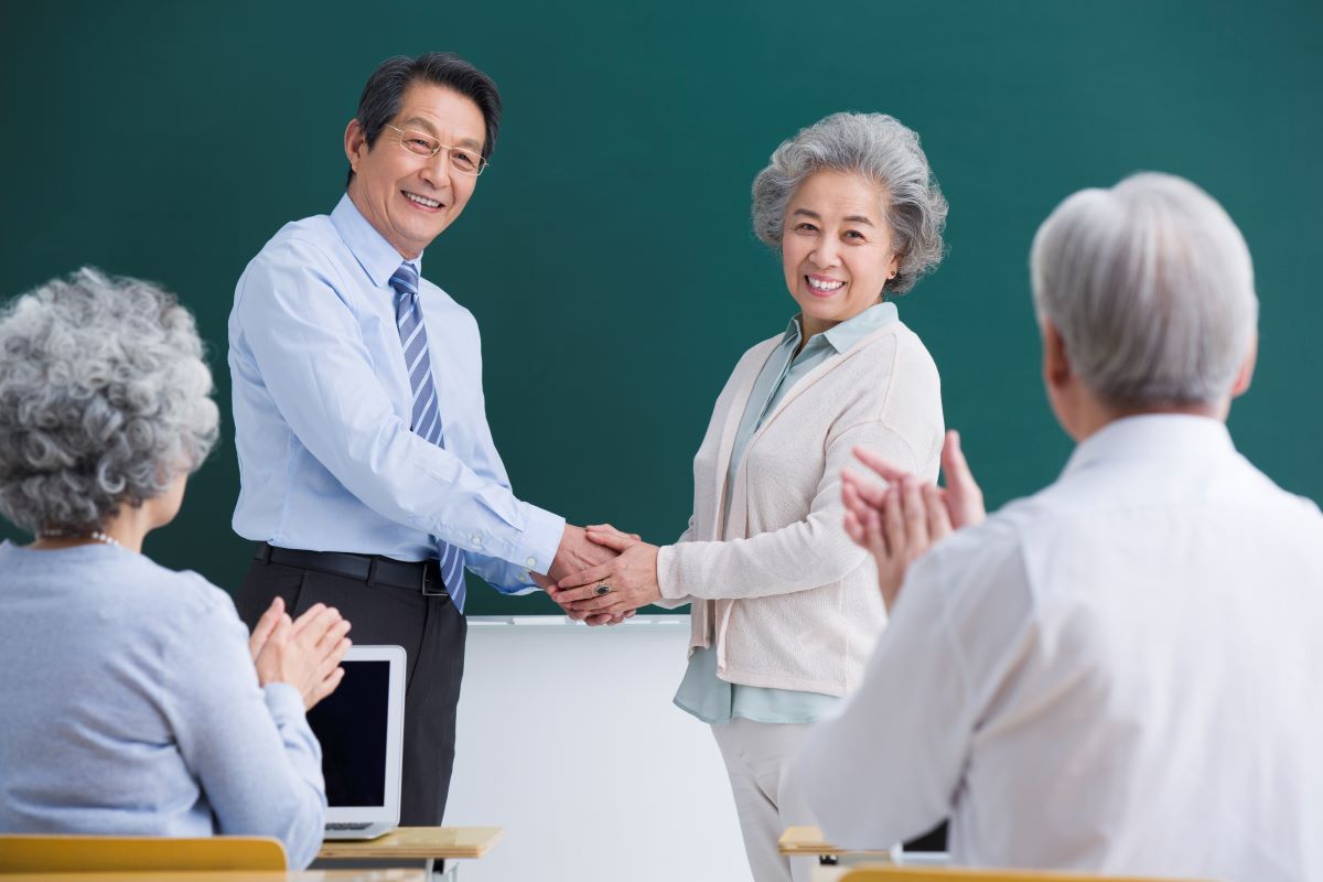 senior student shaking hands with a teacher