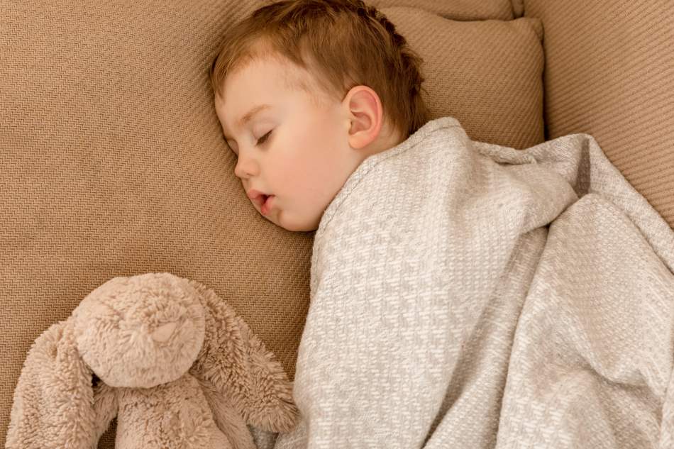 toddler sleeping on a bed