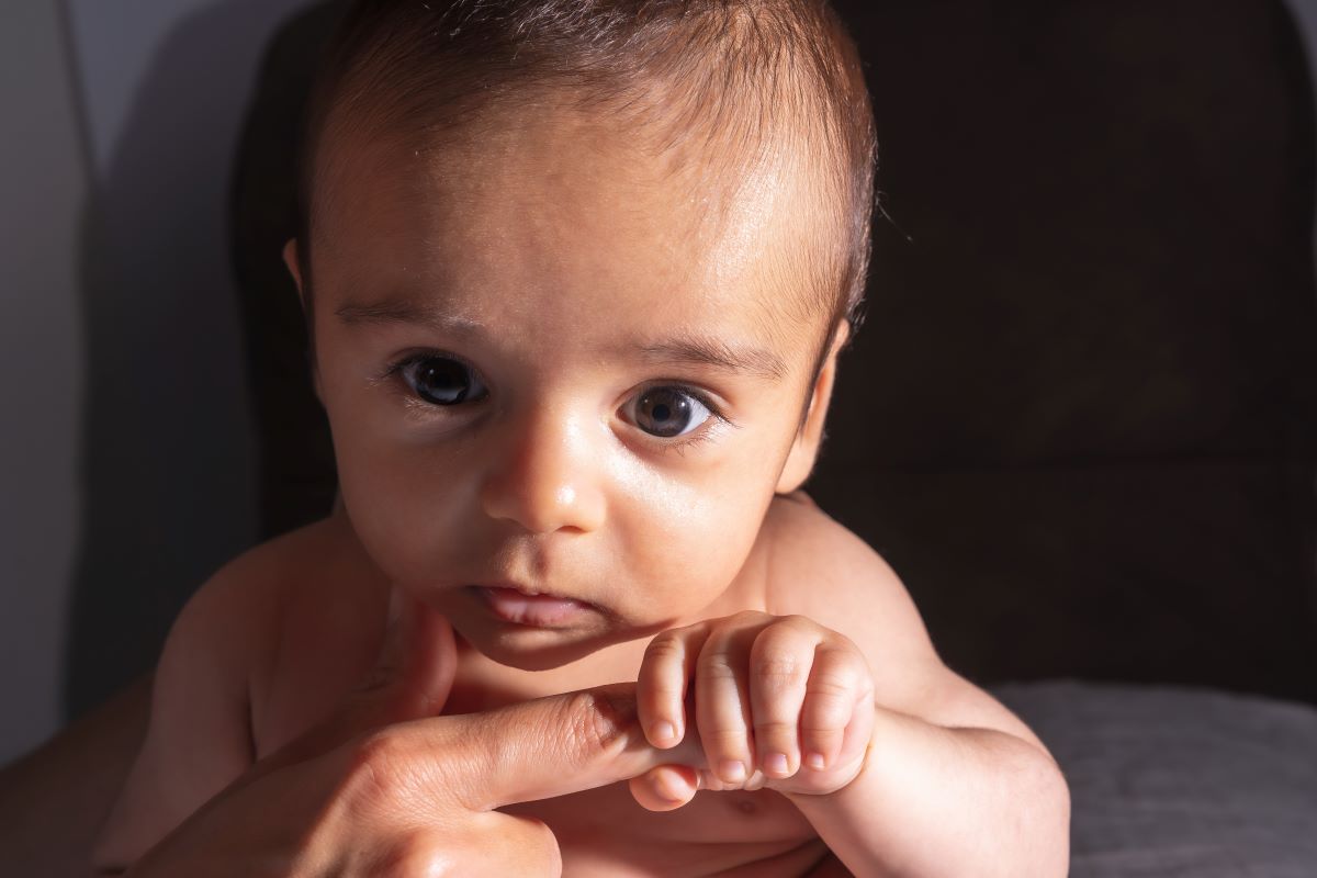 two month old baby sitting on a sofa