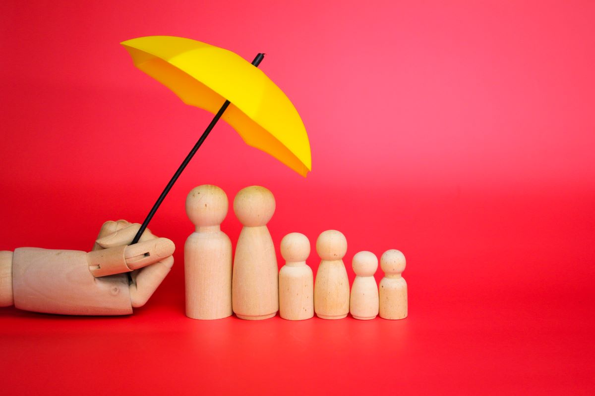 yellow umbrella and a family of wooden figures