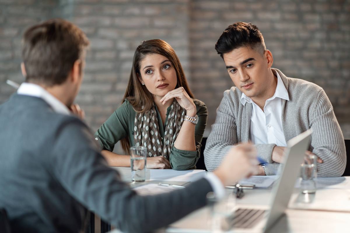 young couple talking to bank manager